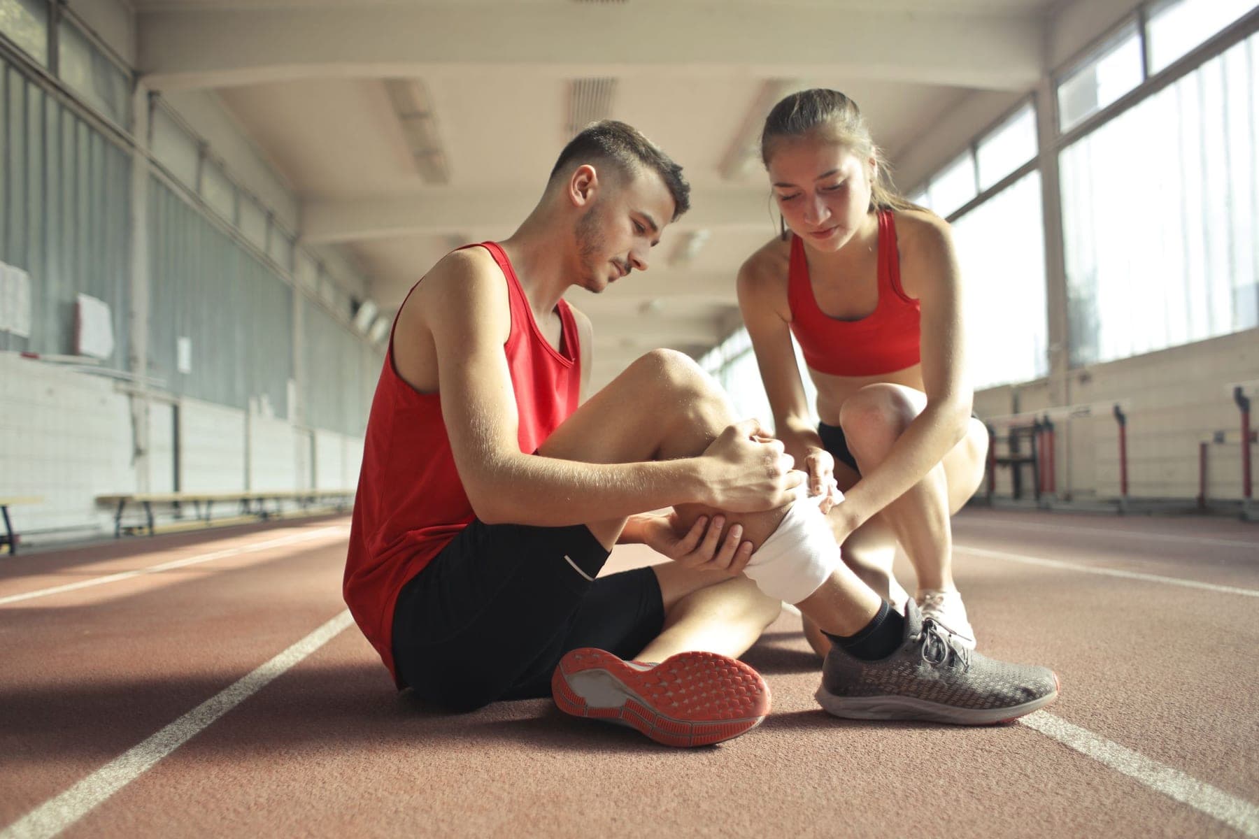 Injured athlete having his leg bandaged