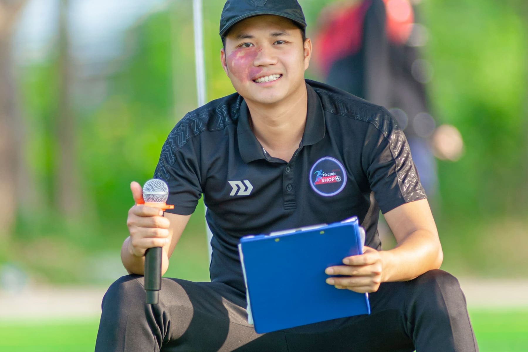 Tournament organizer holding a clipboard at the pitch