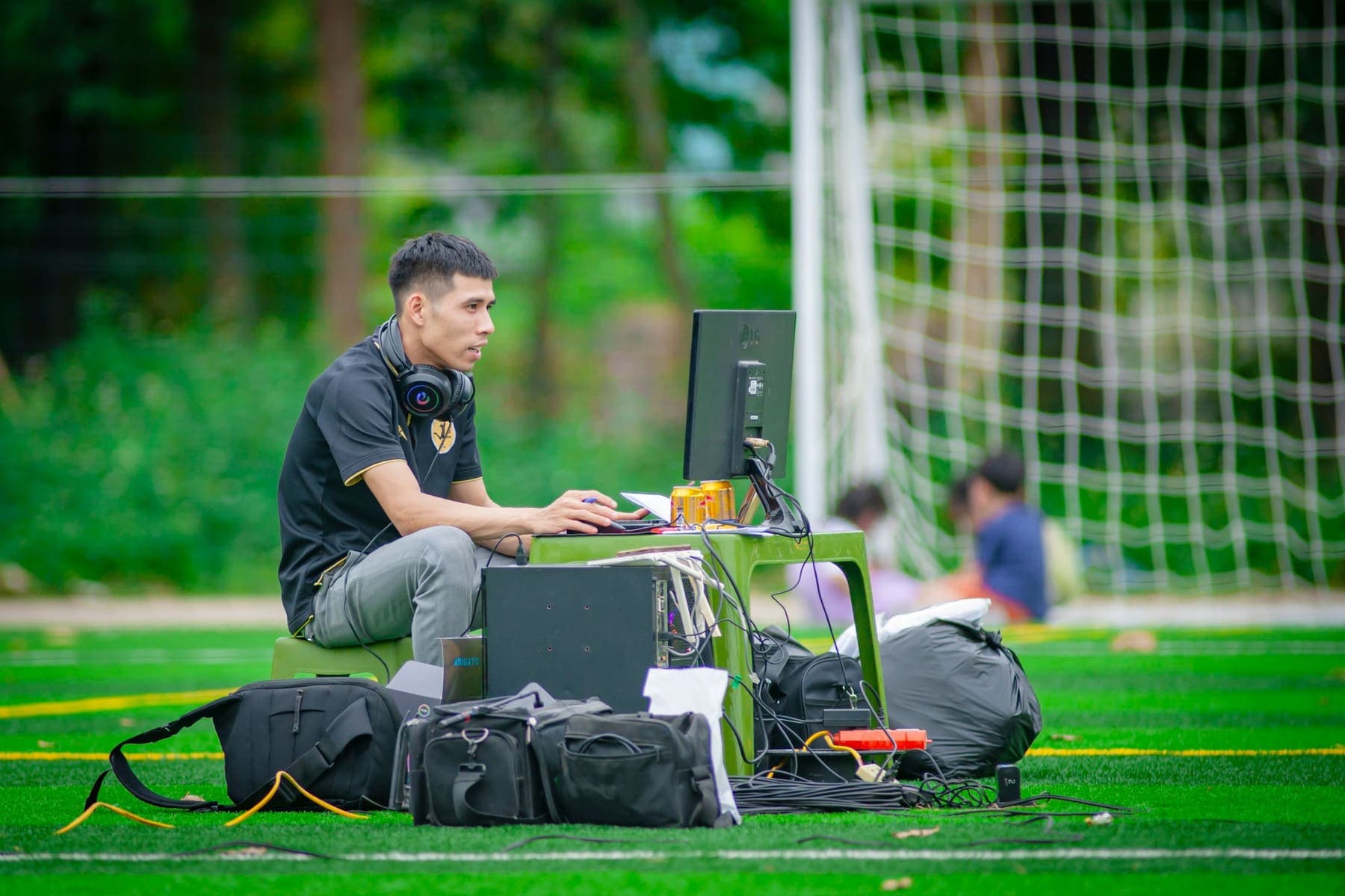 Operator at a VAR monitor beside an artificial pitch