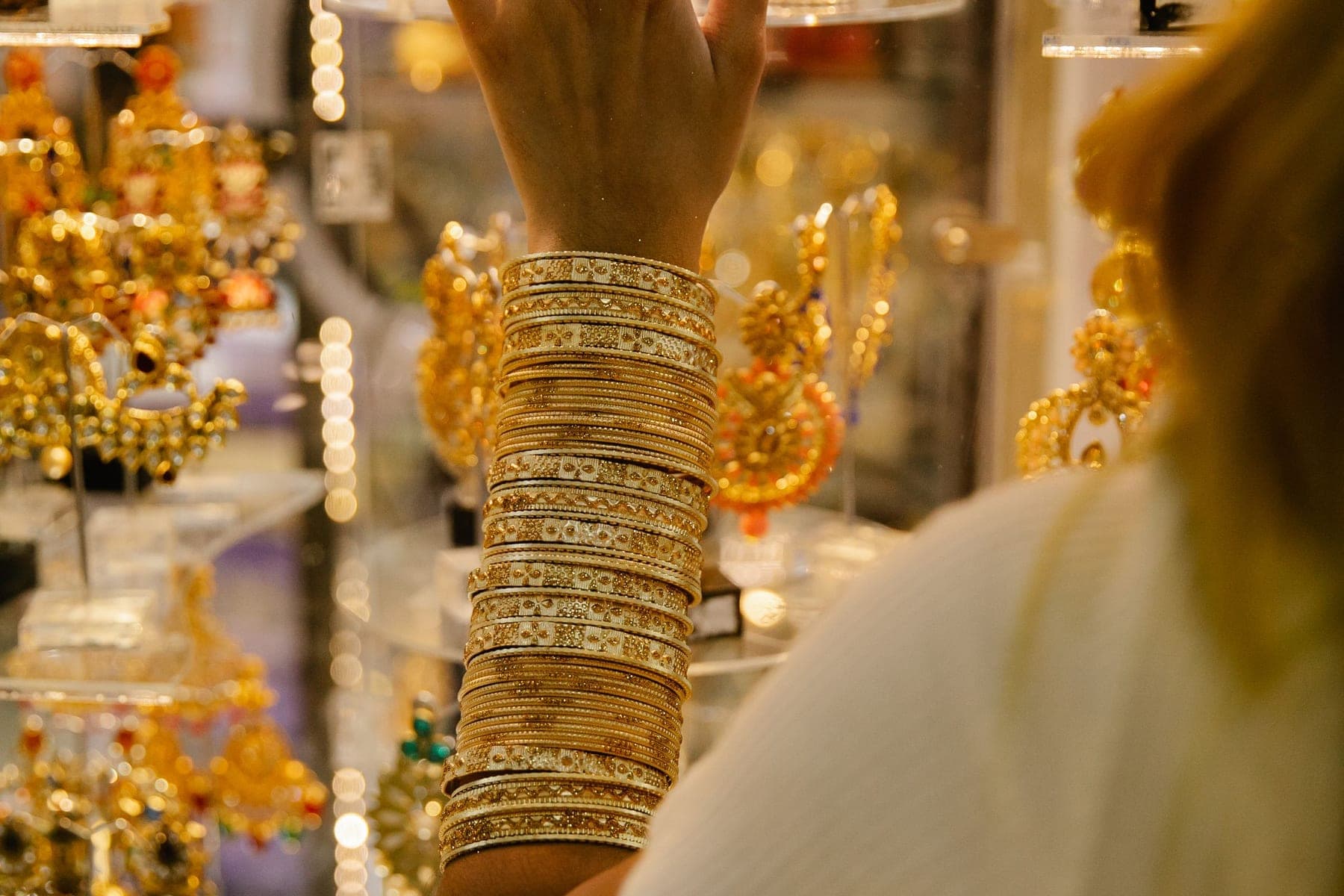 Customer wearing gold bangles at a jewellery display