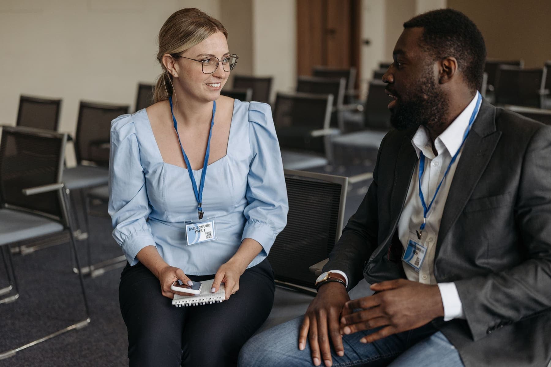 Two staff wearing ID badges talking