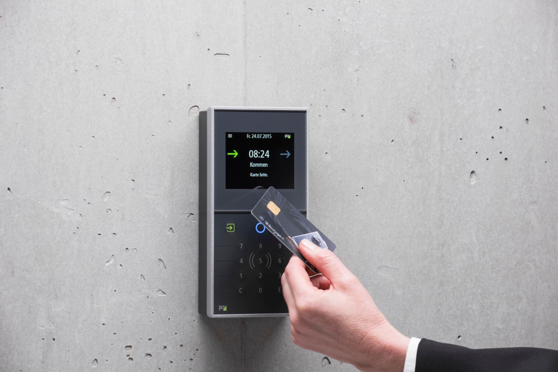 Hand holding an access card to a wall reader