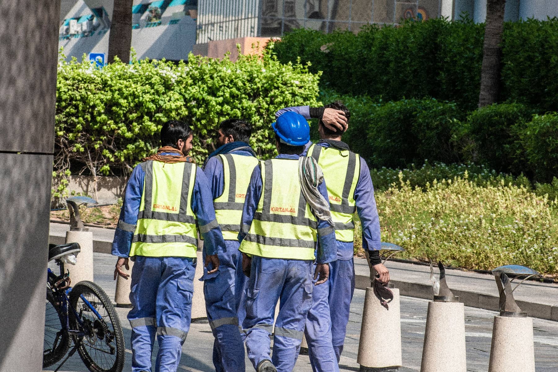 Workers in hi-vis vests walking to an entrance