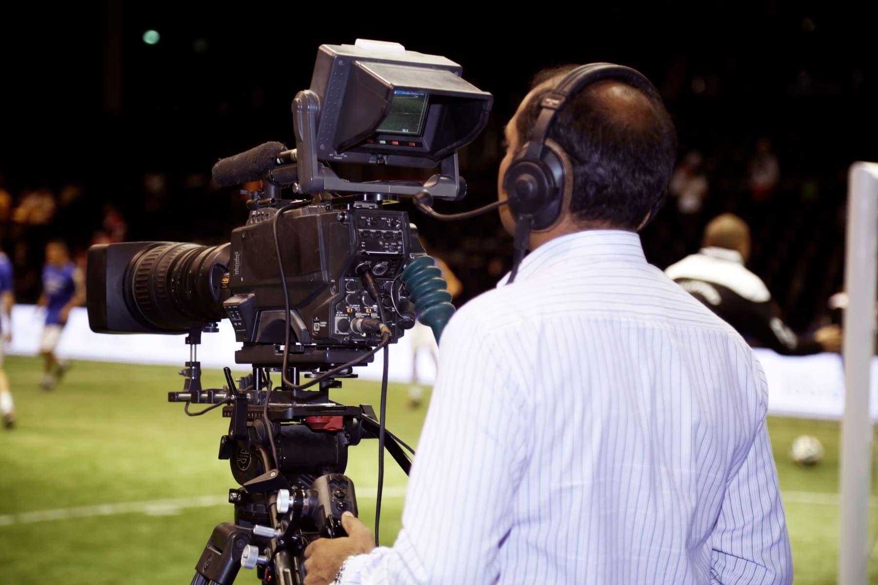 Cameraman filming a football match pitch-side