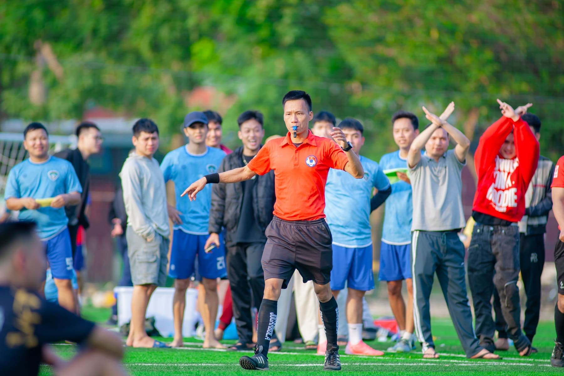 Referee signaling during an amateur match
